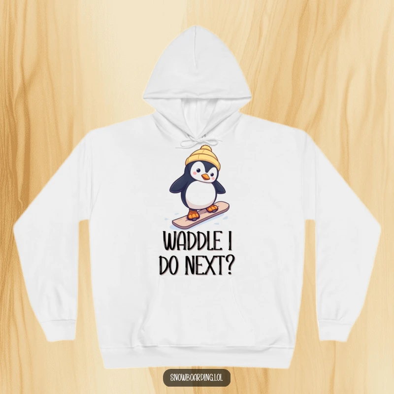 Funny hoodie featuring a curious penguin attempting a snowboard run, illustrating a comical balance act on the snow.
