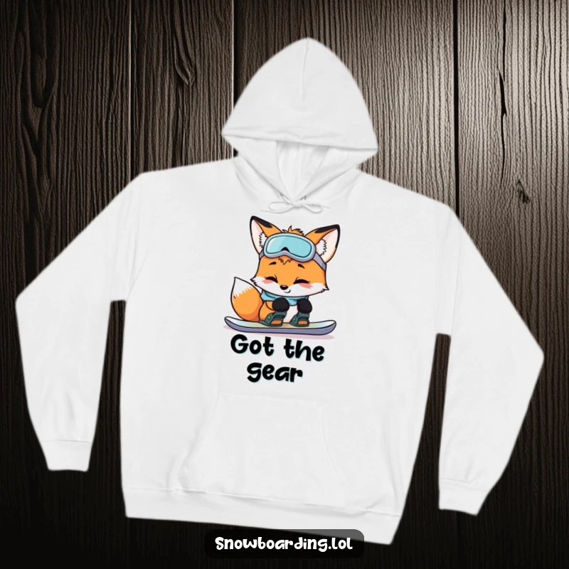 Funny curious fox checking snowboard bindings with a smile, featured on a cozy hoodie for humorous winter readiness.