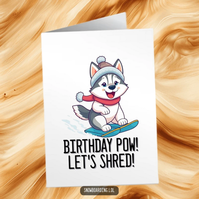 Funny Free Printable Birthday Card: A cheerful husky in a hat snowboard-rocks down a snowy slope, wishing happy birthday.
